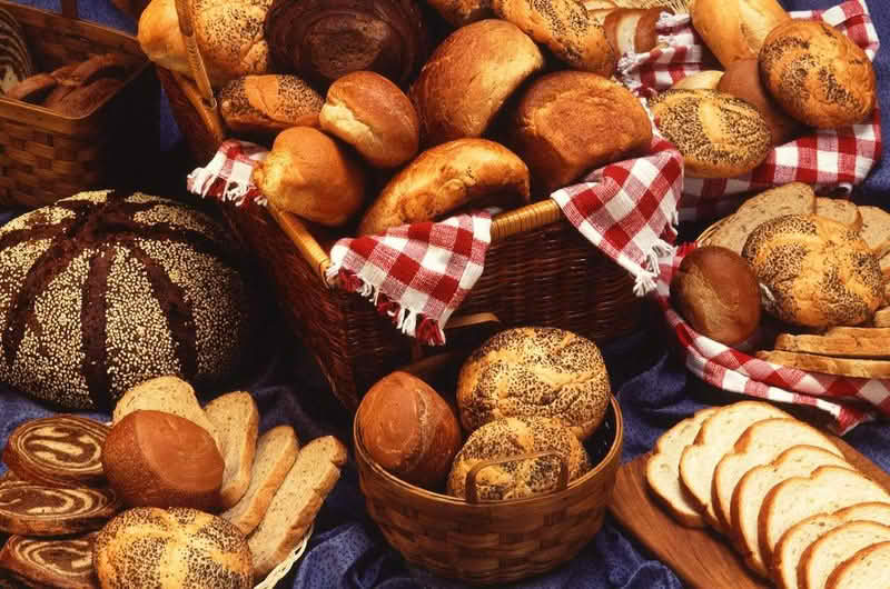 A selection of various breads elegantly arranged on a table, showcasing different shapes and textures