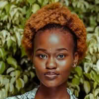 A woman named Olivia Ava with a stylish afro hairstyle, radiating confidence and charm