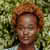 A woman named Olivia Ava with a stylish afro hairstyle, radiating confidence and charm