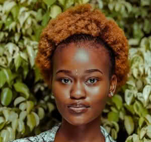 A woman named Olivia Ava with a stylish afro hairstyle, radiating confidence and charm