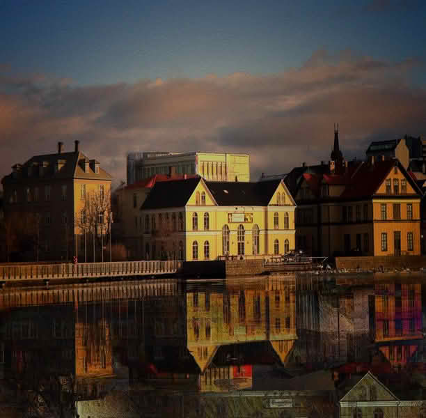 A panoramic view of a large body of water in Reykjavik, reflecting the city's skyline and surrounding landscapes